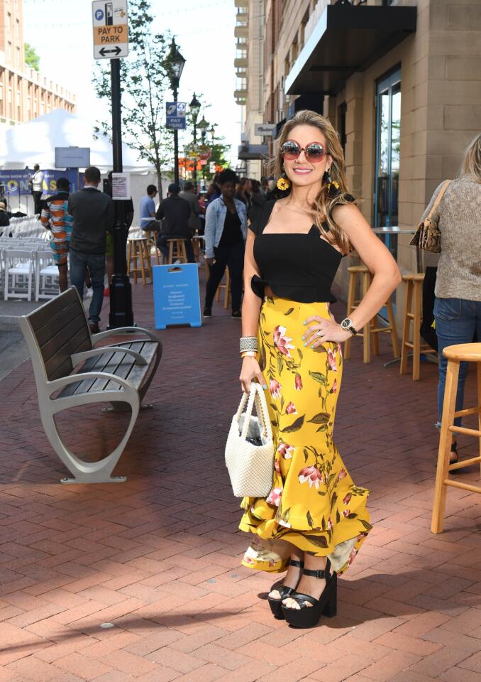 Who: Monica Yu, 33, Clarksville stay-at-home mom Spotted at: 8th Annual FashionEASTa: The Fashion Show at Harbor East What she wore: Aqua black cropped top, mustard and rose print high-low mermaid skirt, and pearl covered mini-tote from Bloomingdale’s; yellow and black flower drop earrings from Zara; handmade raffia cuff from her home country of Colombia; and Wild Fox rose frame sunglasses and Top Shop black wedges from Nordstrom. Her self-described style: “I like tropical colors and ruffles. I’m Hispanic, so my style has a Latin vibe.”
