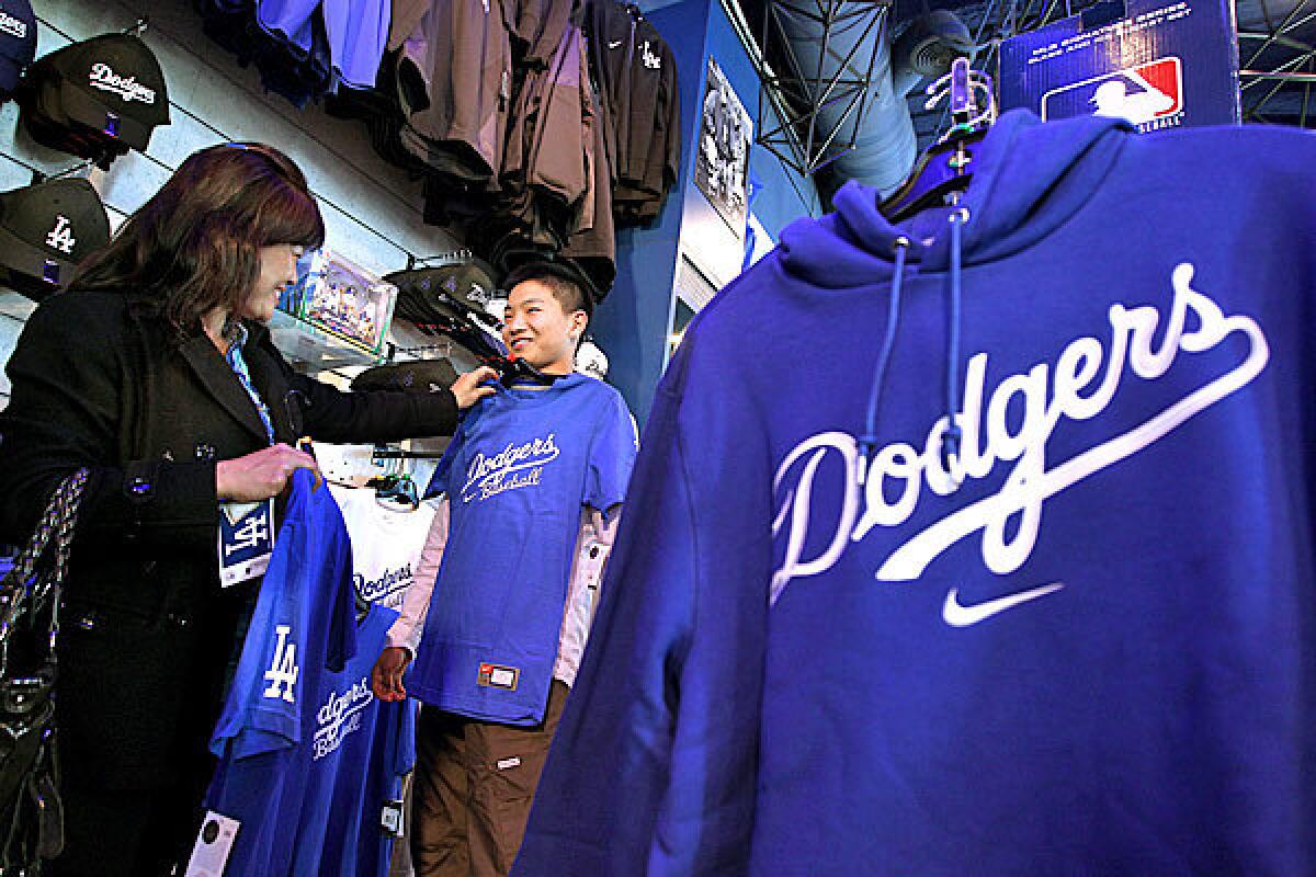 Mika Murade, left, helps her son Riku shop for a Dodgers t¿shirt in the Dodgers Clubhouse Store.