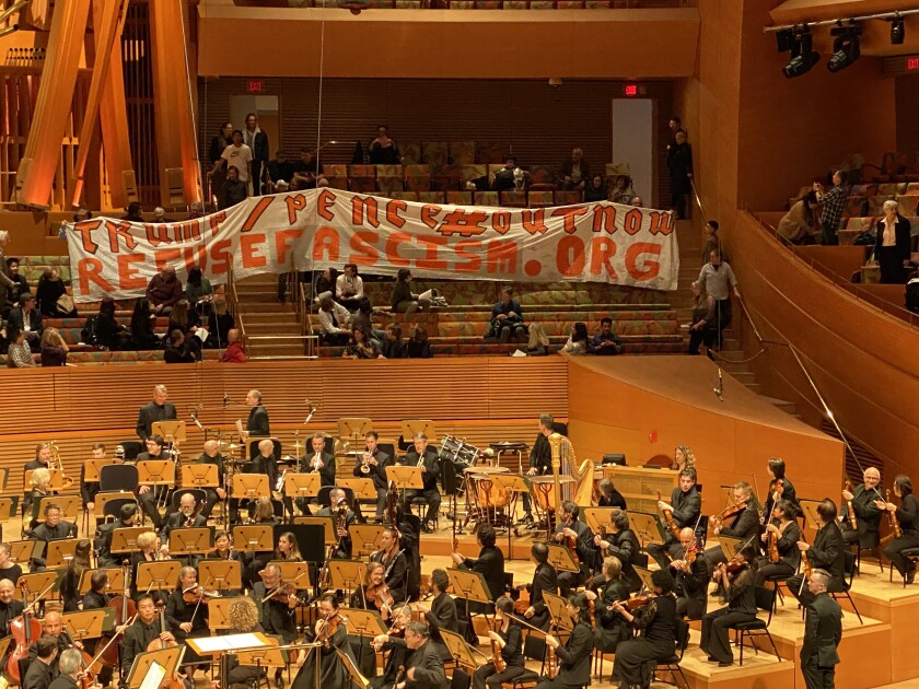 Protesters hoisted a 40-foot banner Friday night during the Los Angeles Philharmonic's opening concert for a Weimar Republic-themed festival.