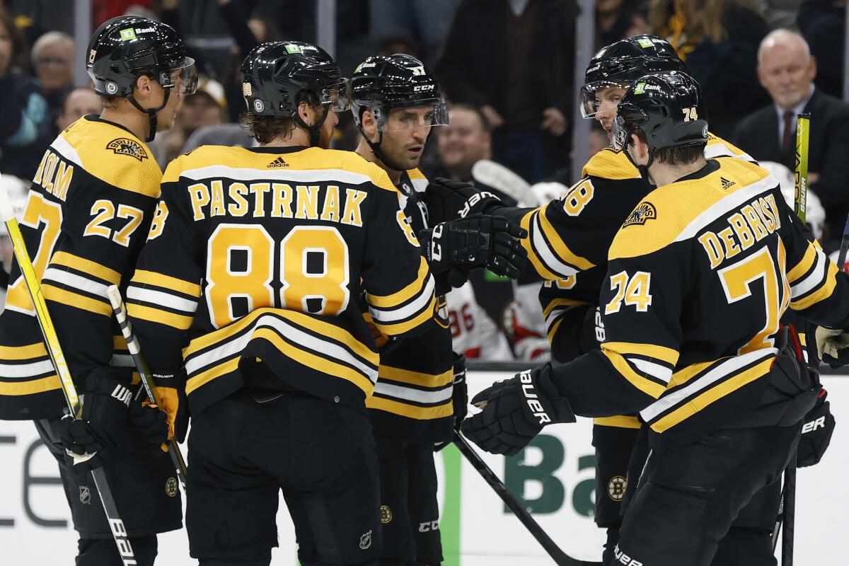 Boston Bruins' Patrice Bergeron (37) and teammates celebrate his goal during the third period of a preseason NHL hockey game against the New Jersey Devils, Saturday, Oct. 8, 2022, in Boston. (AP Photo/Michael Dwyer)