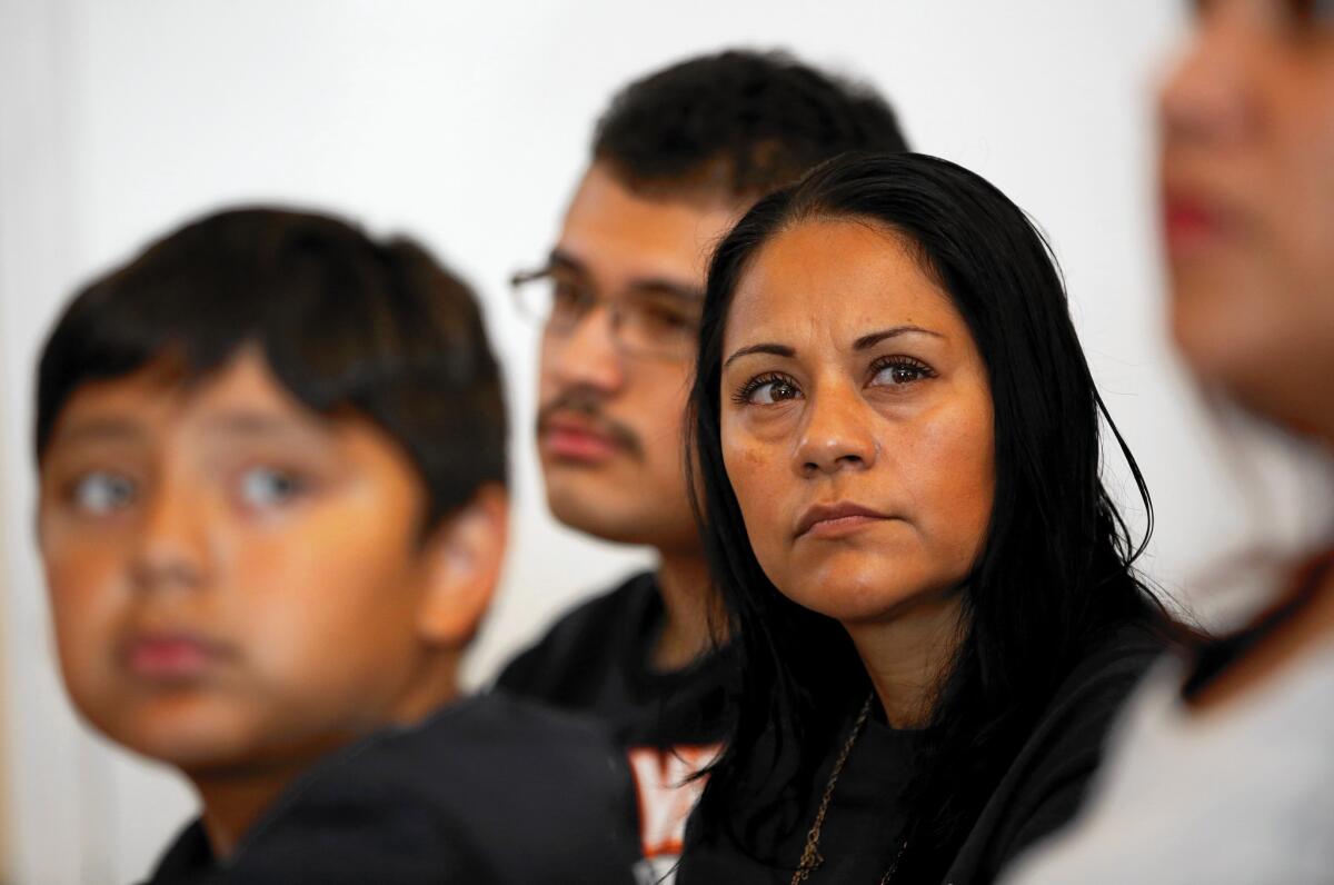 Sujey Becerra, an uninsured immigrant living in San Bernardino County, was unable to pay for the removal of ovarian cysts and now lives in constant pain after emergency surgery. She's shown with her sons Alexandre, 10, left, and Gonzalo Cervantes, 16.