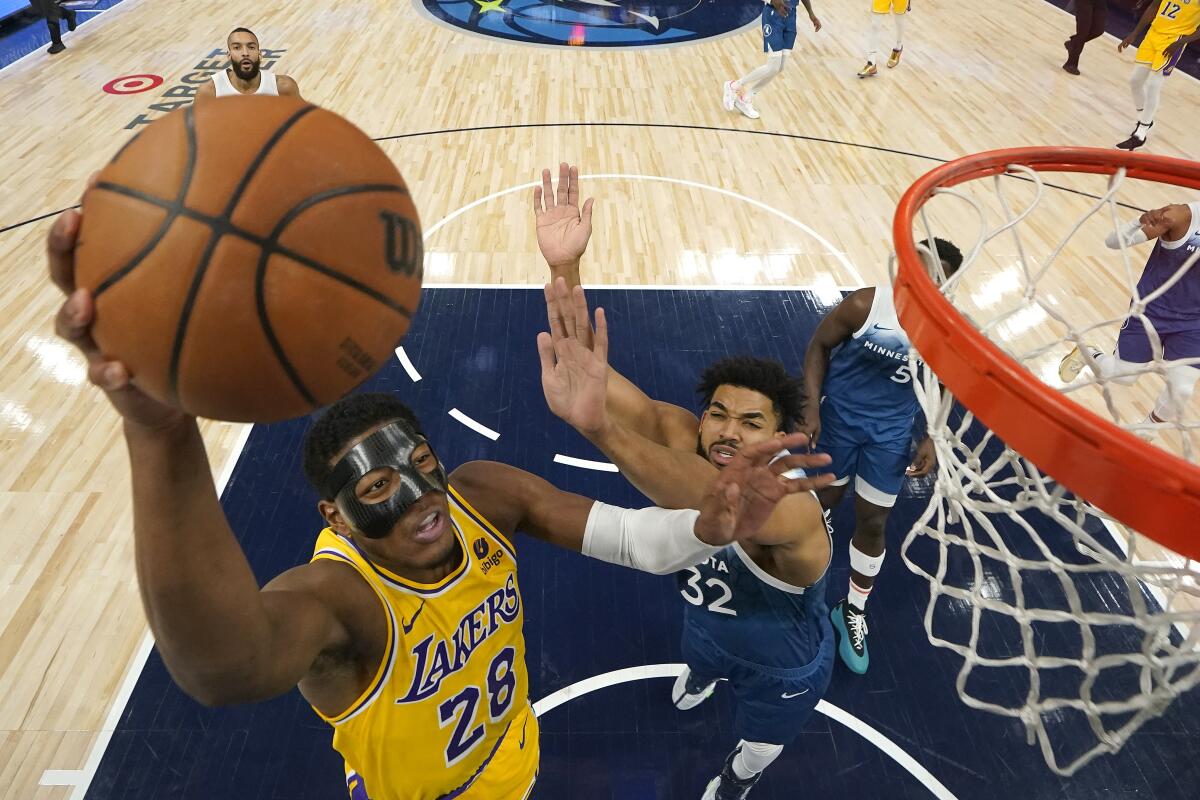 Lakers forward Rui Hachimura, left, has his layup challenged by Timberwolves forward Karl-Anthony Towns.