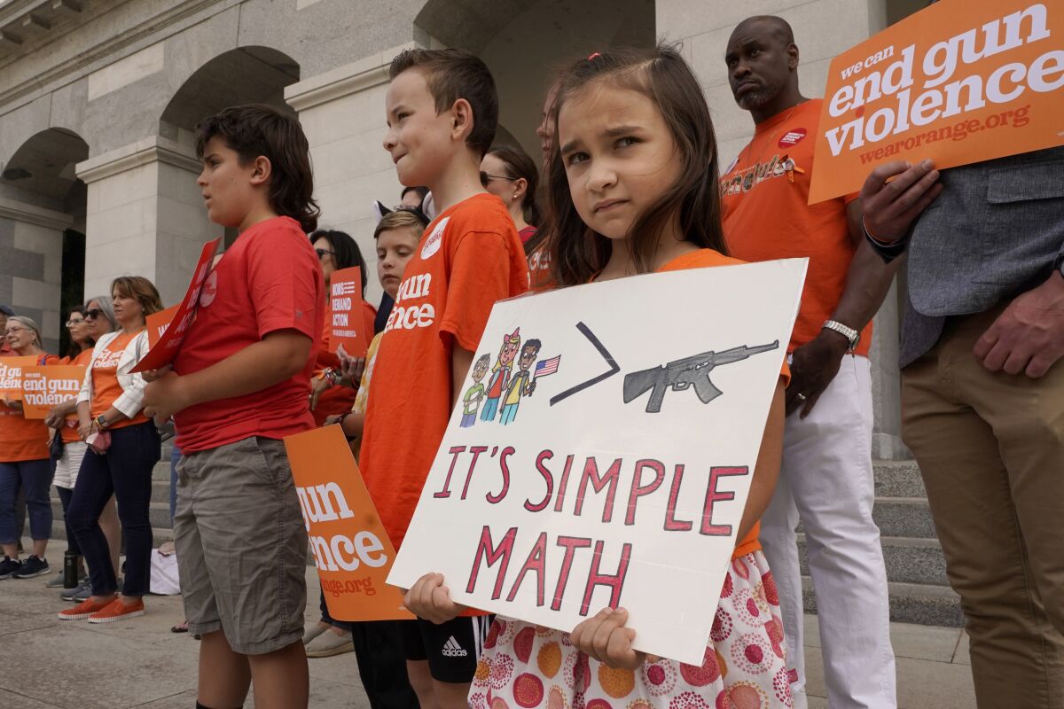 Elise Schering, 7, displays a simple message during a National Gun Violence Awareness rally at the Capitol in Sacramento, Calif., on Thursday, June 2, 2022. In acknowledgment of Gun Violence Awareness Day, Gov. Gavin Newsom announced on Friday, June 3, 2022, that California is spending $11 million on education programs promoting wider use of "red flags" orders that are designed to temporarily take guns away from people who are deemed at risk of harming themselves or others. (AP Photo/Rich Pedroncelli)