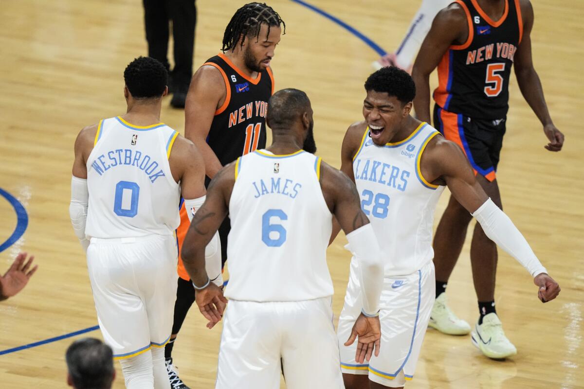 Lakers' Rui Hachimura celebrates with LeBron James and Russell Westbrook as New York Knicks' Jalen Brunson walks past them.