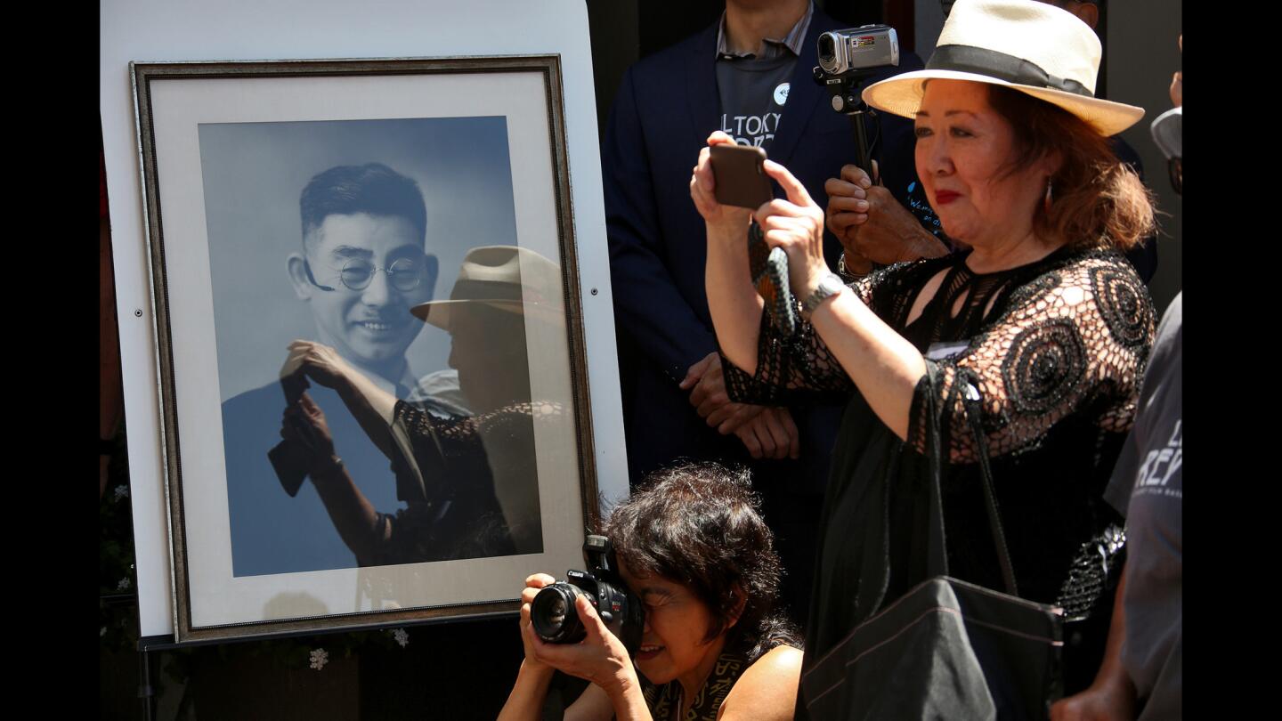 Attendees take photos at the unveiling of a monument honoring Sei Fujii. Fujii immigrated to California in 1903 and attended law school at USC. Because he was not a citizen, he was unable to become a lawyer. But for decades he teamed with a former USC classmate to fight legal battles on behalf of the Japanese American community.