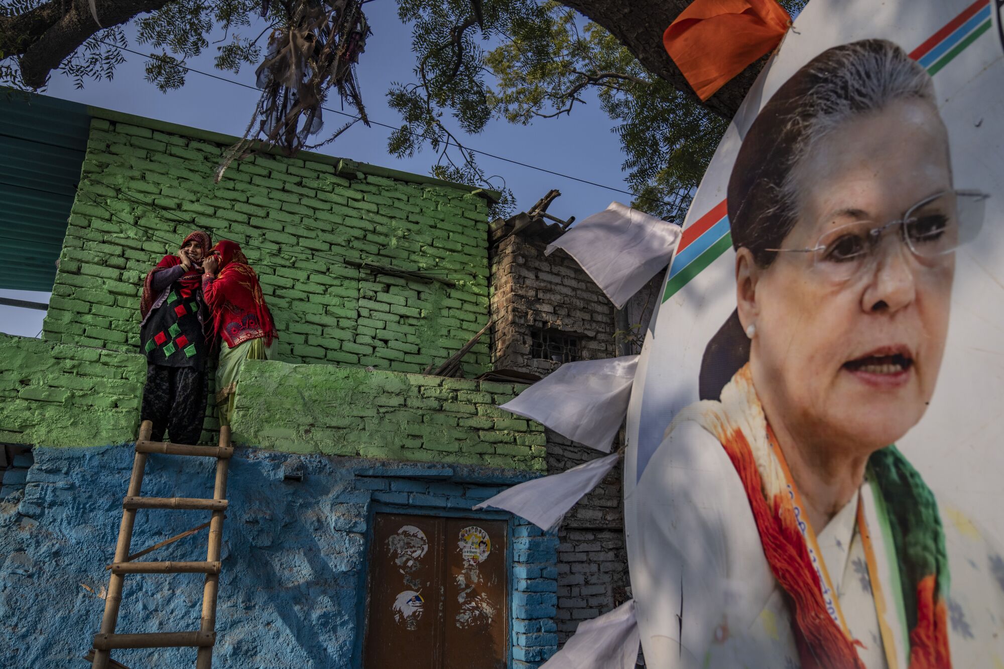 Women watch from their house as Rahul Gandhi, leader of India's opposition Congress party, march