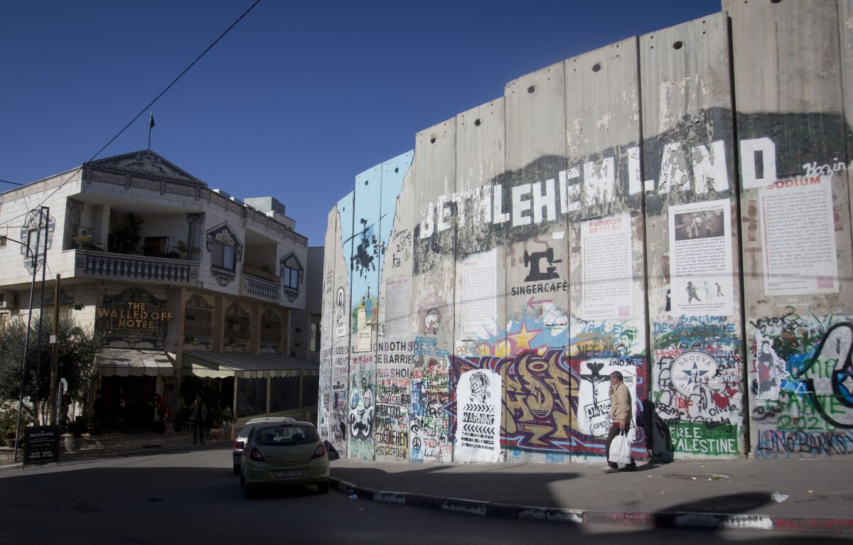 The Israeli security barrier stands near the Walled Off Hotel where a new artwork dubbed "Scar of Bethlehem" by artist Banksy is displayed in the West Bank city of Bethlehem.