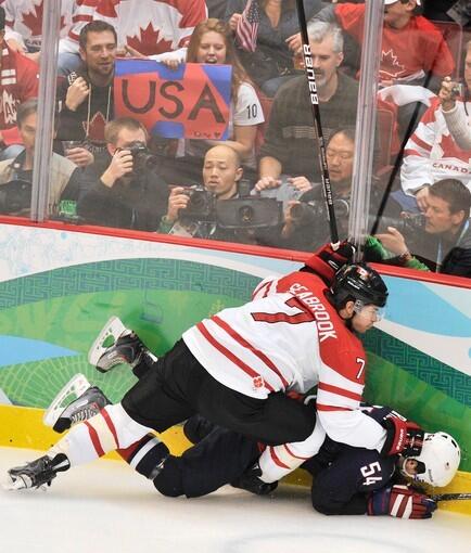 Canada's Brent Seabrook falls on USA's Bobby Ryan during the gold medal game.