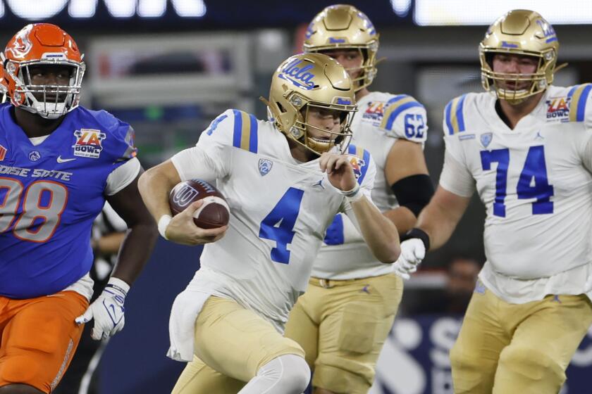 Los Angeles, CA - December 16: UCLA QB Ethan Garbers scrambles for a first down.