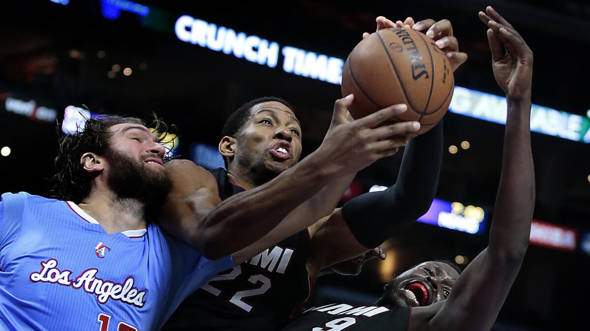 Clippers forward Spencer Hawes, left, battles Miami Heat forwards Danny Granger, center, and Luol Deng for a rebound during the second half of the Clippers' 104-90 loss at Staples Center on Sunday.