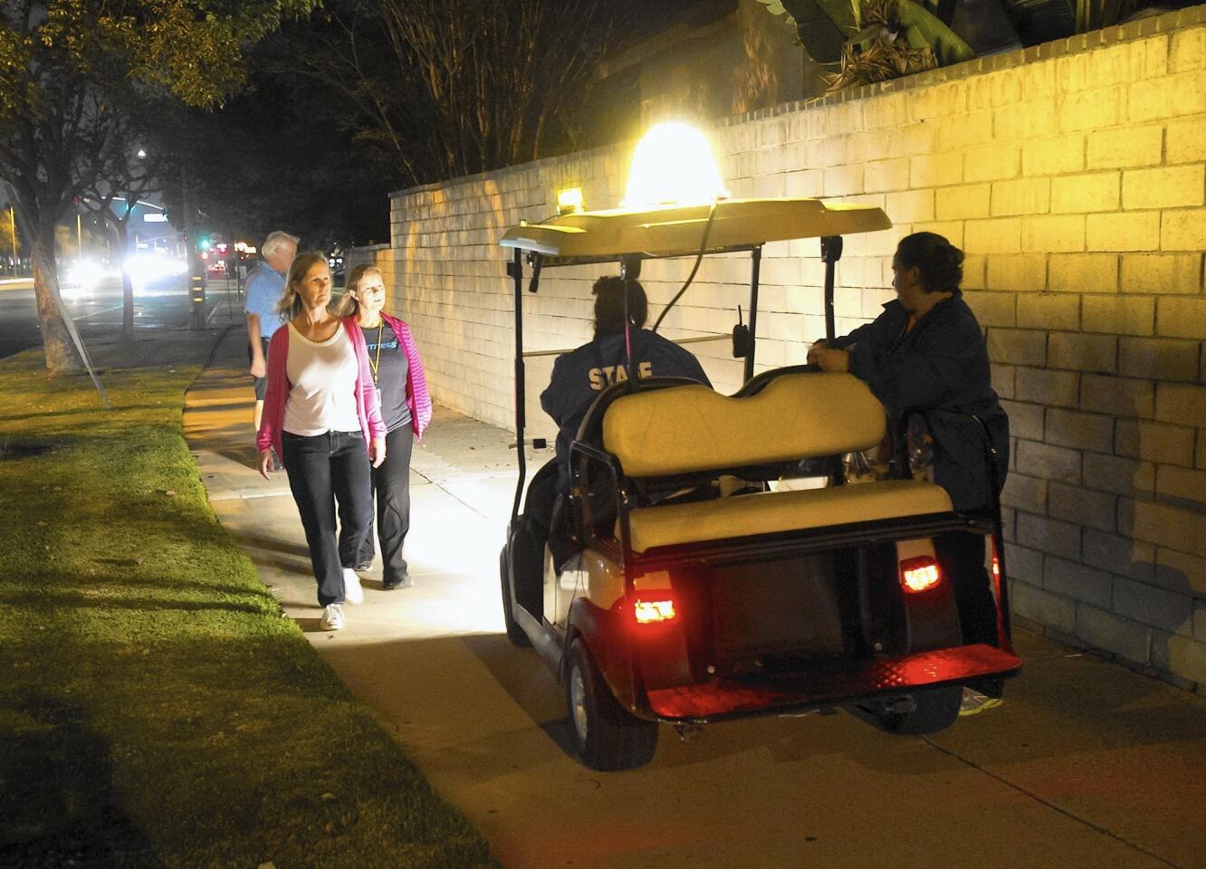 OC Fair ambassadors Jenny Jones and Janet Chompff, in the golf cart, chat with neighbors returning from the OC Fair. The pair go around Costa Mesa neighborhoods to greet folks and pick up trash, among other things.