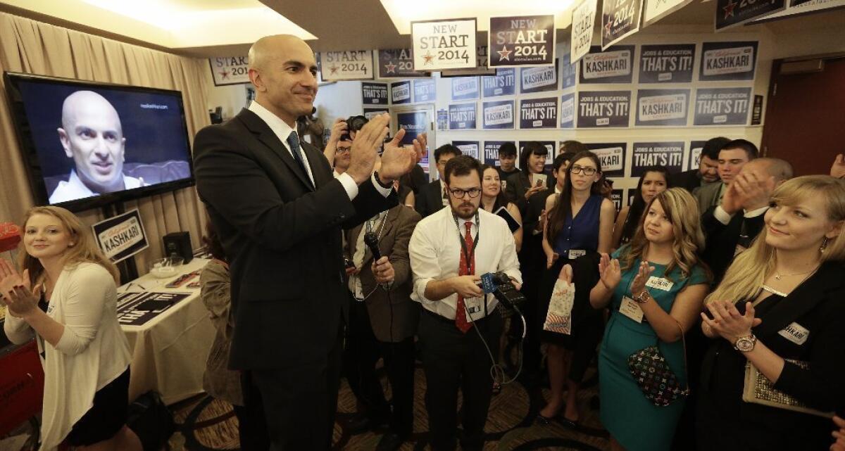 Neel Kashkari, who is seeking the GOP nomination for California governor, speaks with campaign workers during the state Republican Party's convention in Burlingame, Calif.