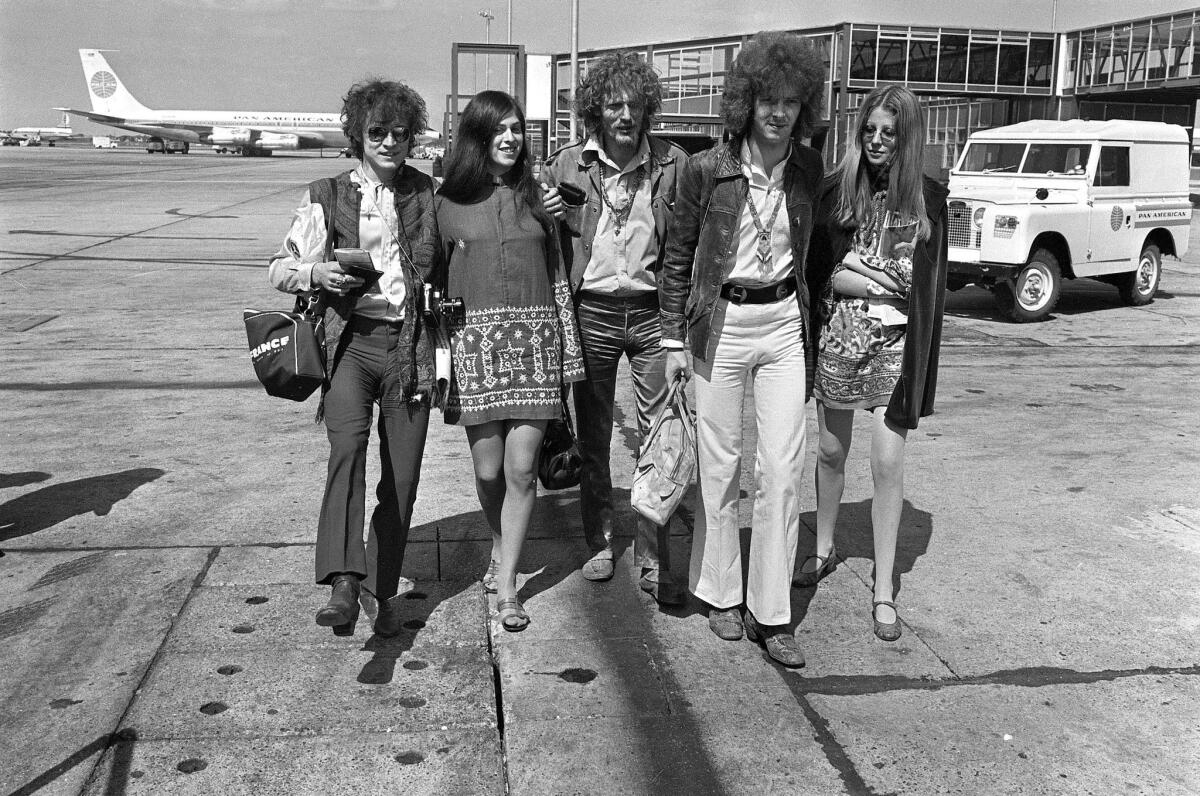 In this Aug. 20, 1967 file photo, members of the rock group Cream are shown departing for a tour from Heathrow Airport in London. From left are Jack Bruce, Ginger Baker and Eric Clapton, accompanied by two unidentified women.