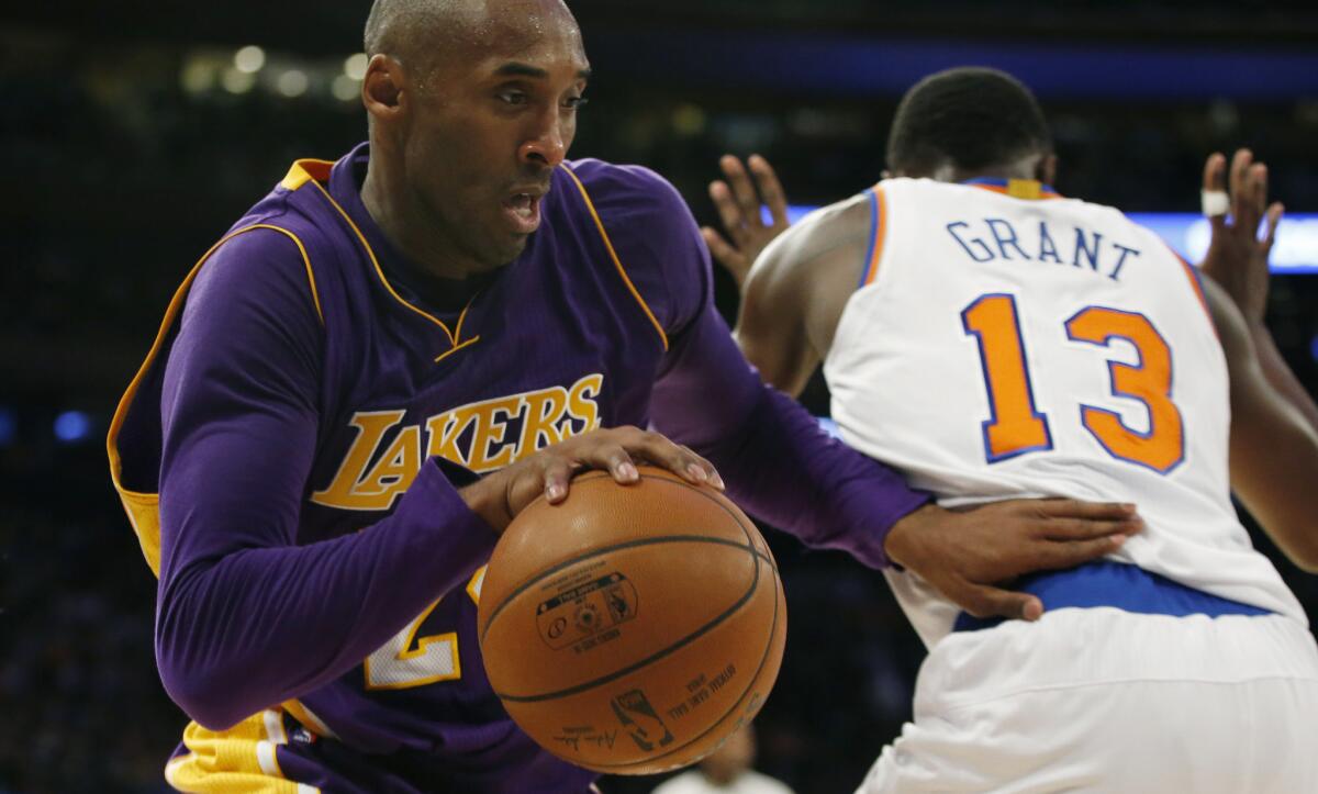 The Lakers' Kobe Bryant drives around New York guard Jerian Grant on Sunday.