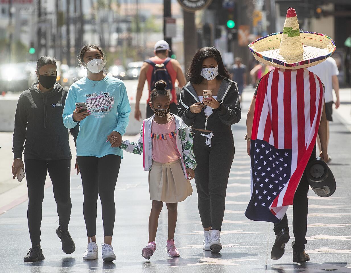 Jair Guido, right, walks with other pedestrians along Hollywood Boulevard in Hollywood.