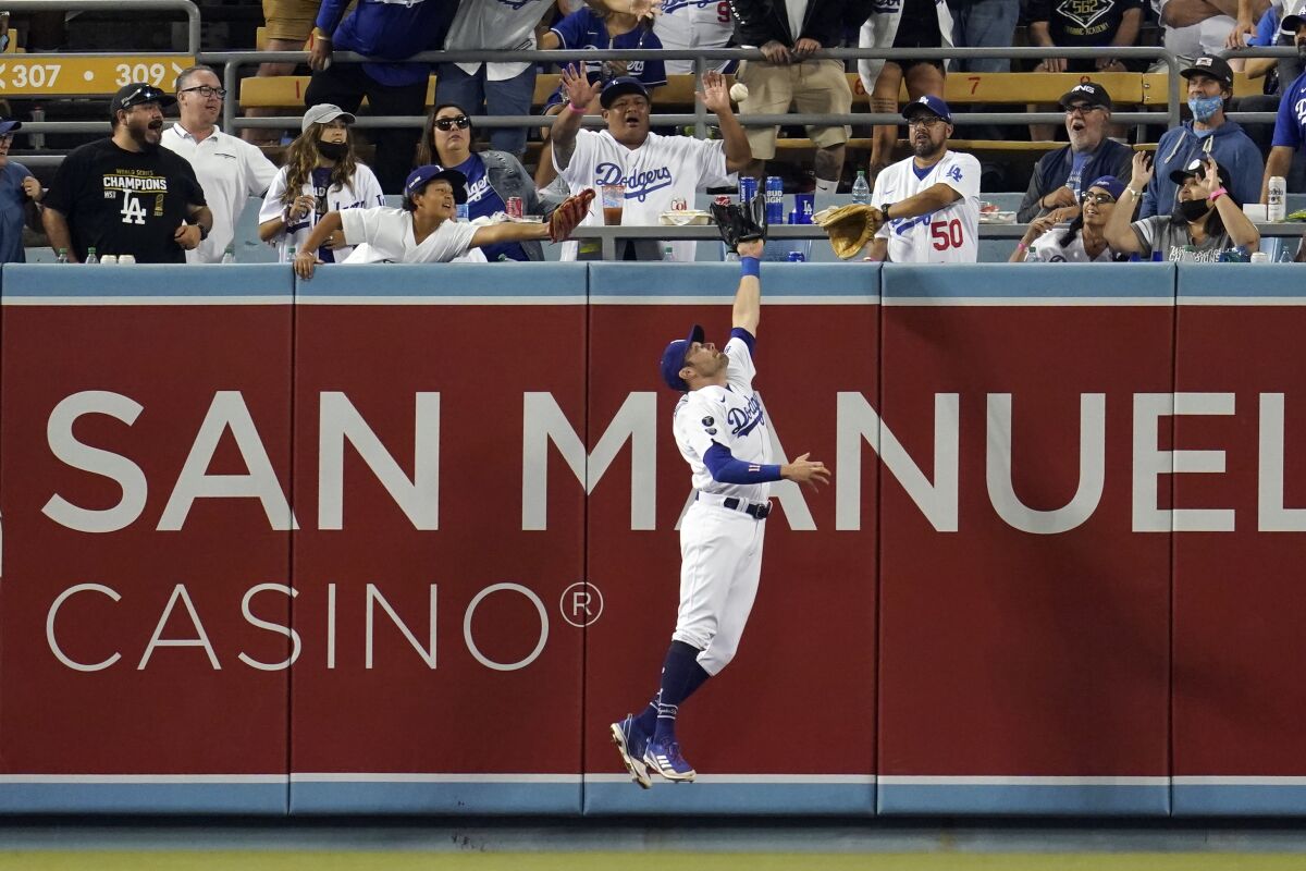 Dodgers left fielder AJ Pollock leaps for but can't make the catch on a home run.
