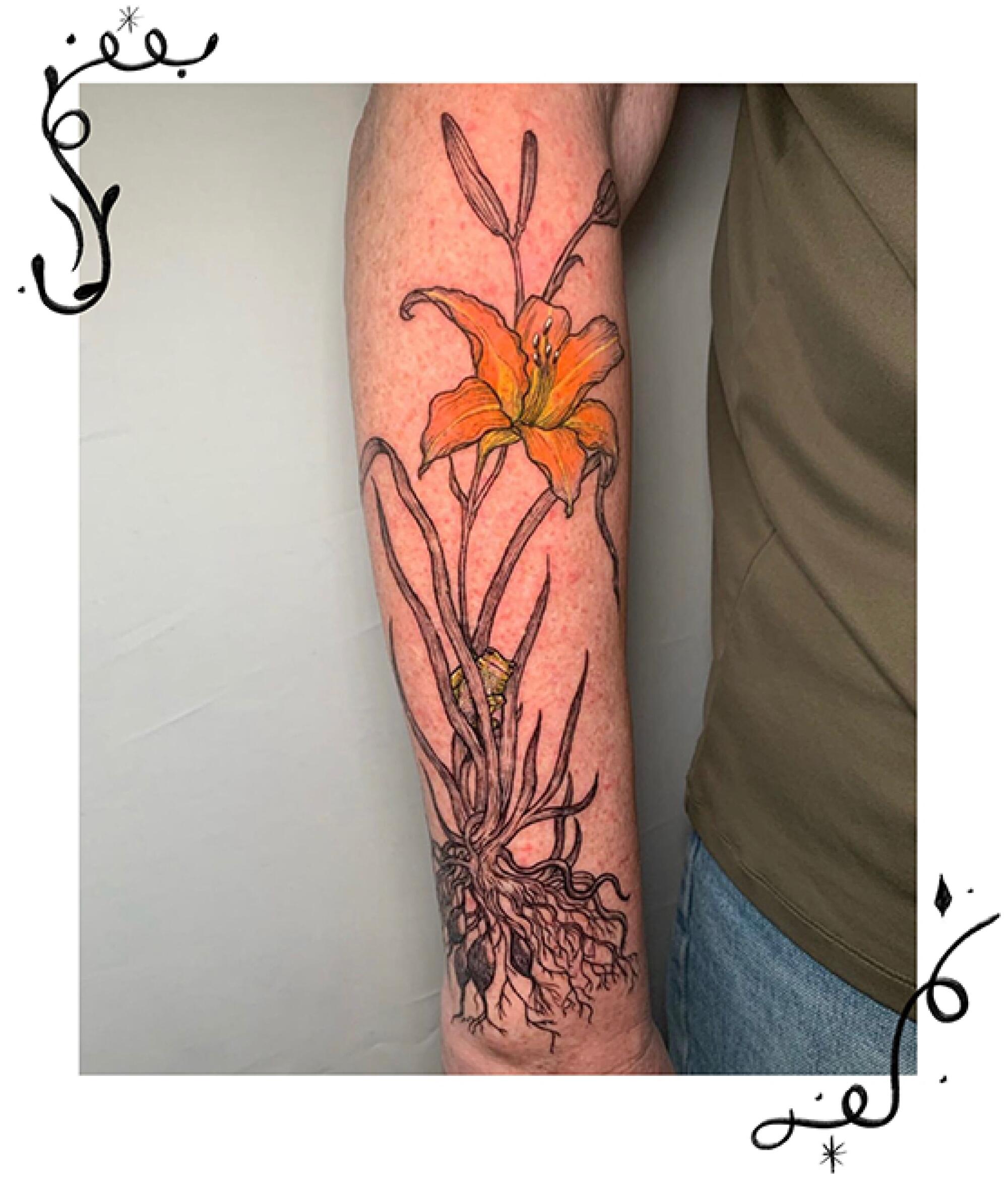 A day lily tattoo on an arm.