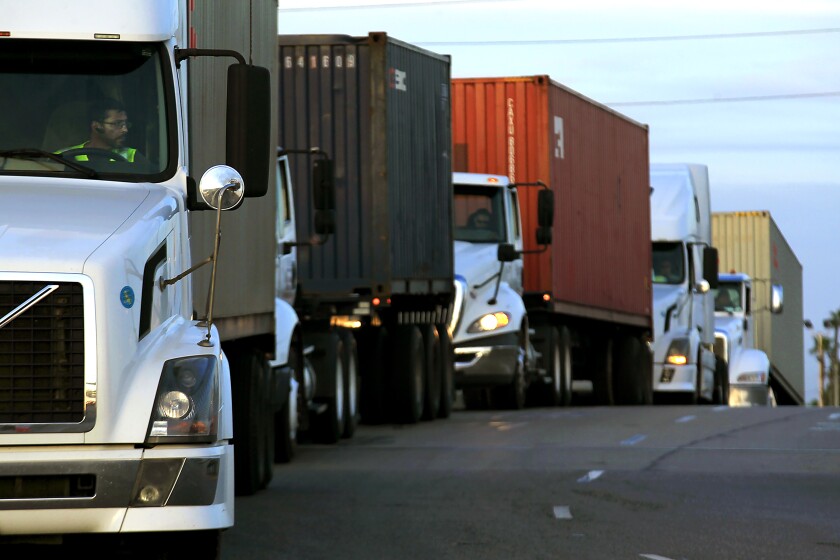 Trucks wait in line to take cargo to a pier in the Port of Long Beach 
