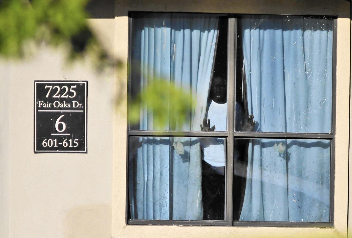 A child looks out from an apartment in Dallas where relatives of Thomas Eric Duncan, the Liberian who died of Ebola after arriving, are living.