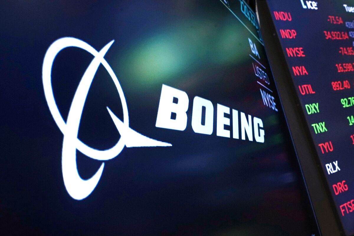 The logo for Boeing appears on a screen above a trading post on the floor of the New York Stock Exchange.