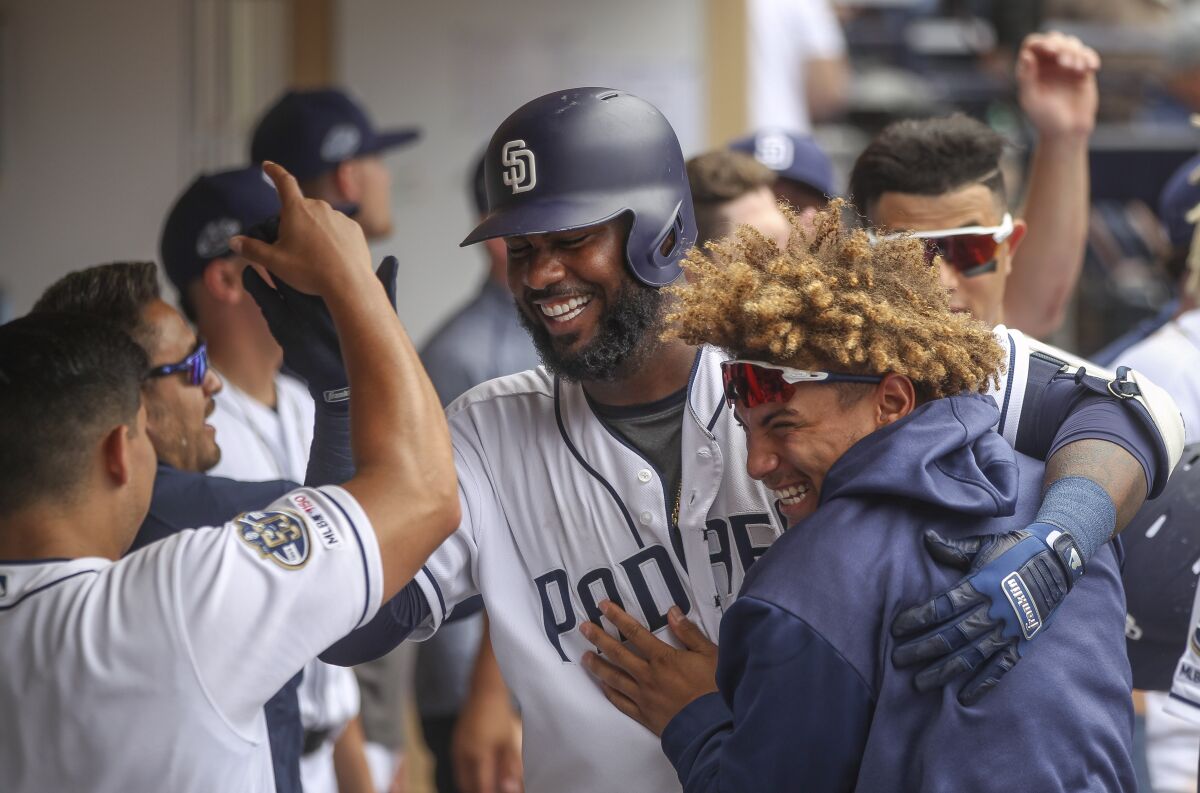 Franmil Reyes, center, hugs Josh Naylor as he celebrates a three-run homer in a game with the Padres