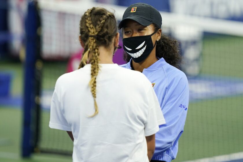 Naomi Osaka, of Japan, right, talks with Victoria Azarenka, of Belarus, left, at the Western & Southern Open tennis tournament during a trophy ceremony Saturday, Aug. 29, 2020, in New York. Osaka pulled out of the Western & Southern Open final Saturday because of a left hamstring injury, giving the title to Victoria Azarenka, of Belarus. (AP Photo/Frank Franklin II)