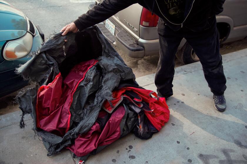 LOS ANGELES, CALIF. - OCTOBER 09: A man identified as “Freddy” shows the hole in his tent that was made by a incendiary device that was tossed at his tent, at the Sunset blvd. underpass along Glendale blvd. in Echo Park on Wednesday, Oct. 9, 2019 in Los Angeles, Calif. (Kent Nishimura / Los Angeles Times)