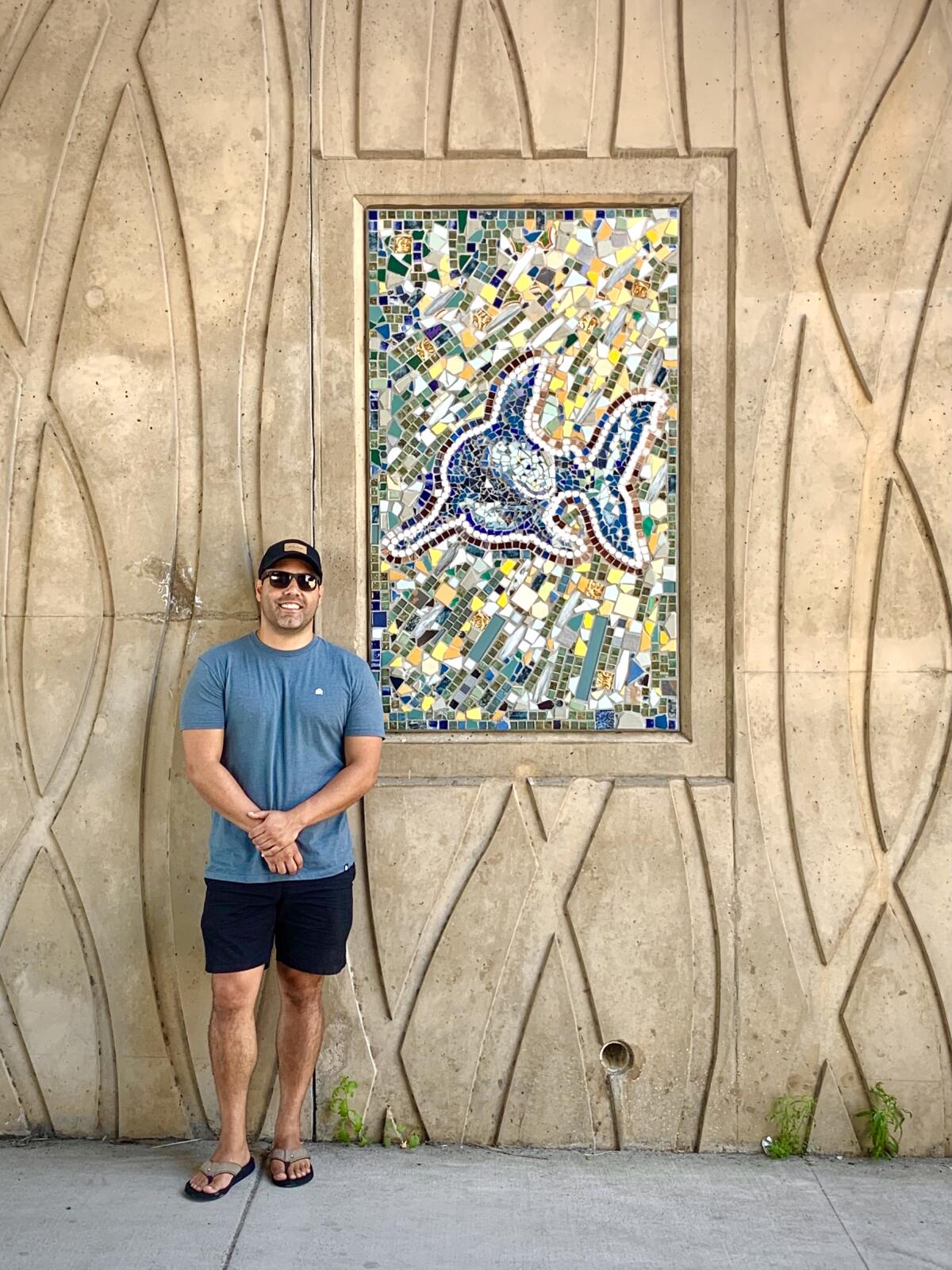 Artist Pietro Martinez next to his mosaic "Ruby the Shark."