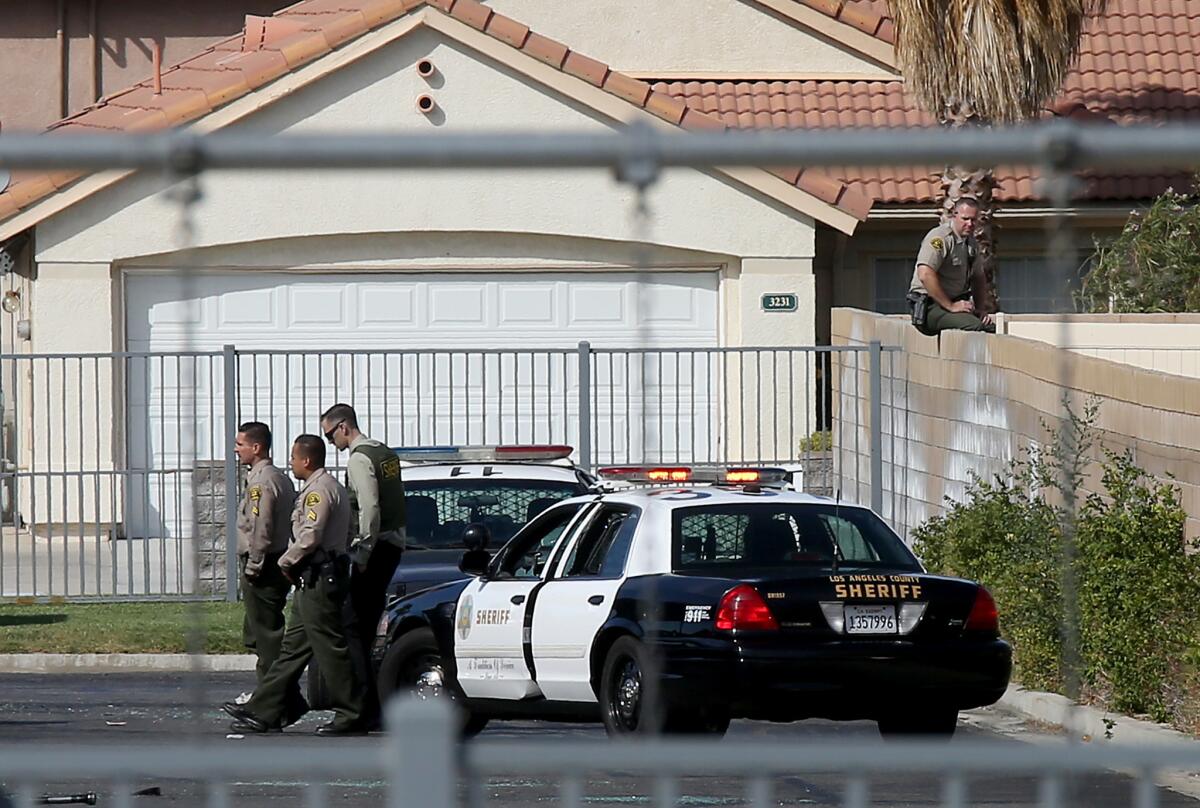 L.A. County sheriff's deputies stand near the fatal shooting scene in Lancaster on Wednesday afternoon.