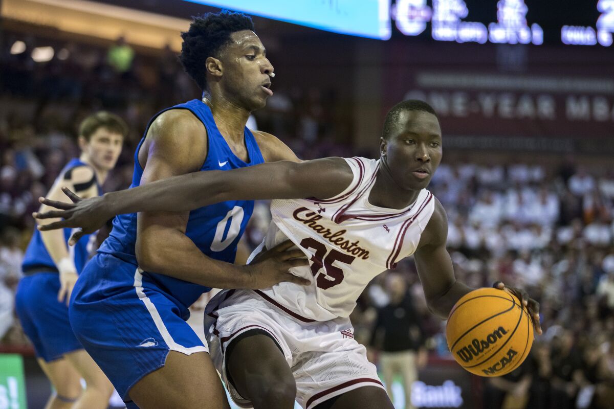 Charleston forward Babacar Faye (35) is guarded by Hofstra forward Warren Williams (0) during the first half of an NCAA college basketball game, Saturday, Jan. 28, 2023, in Charleston, S.C. (AP Photo/Stephen B. Morton)