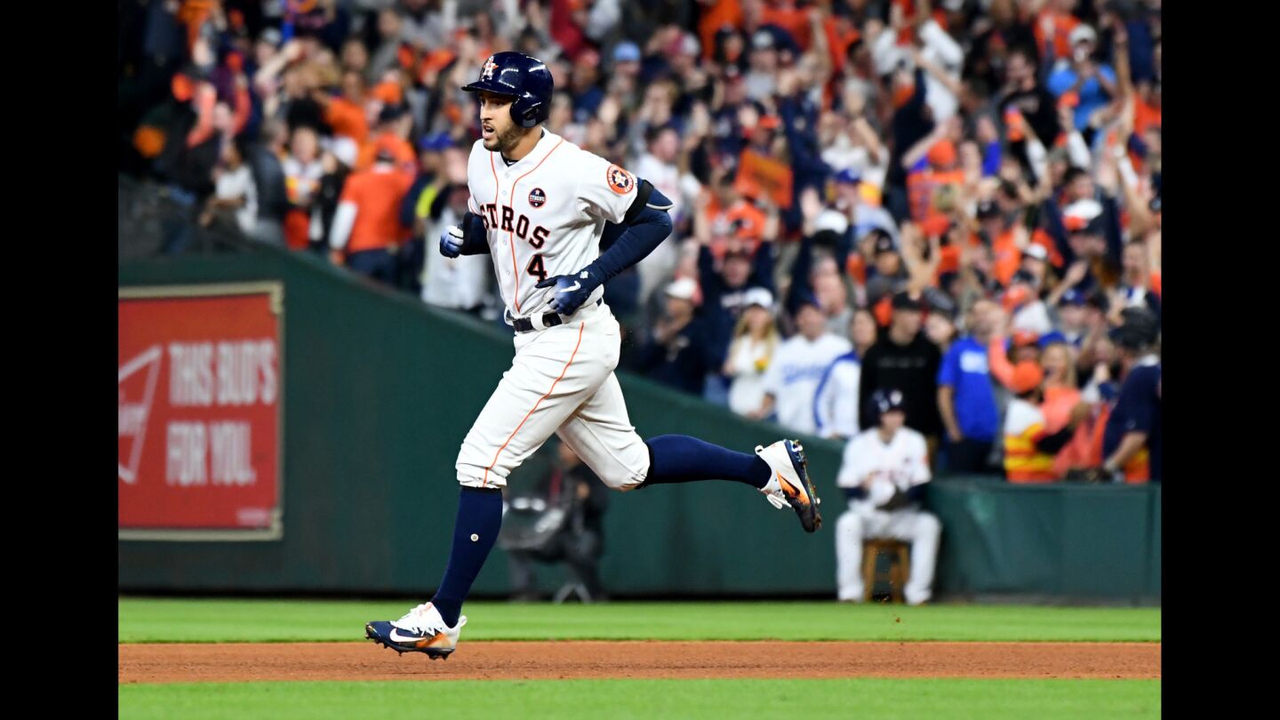 The Astros' George Springer hits a solo home run against Dodgers pitcher Alex Wood in the sixth inning.