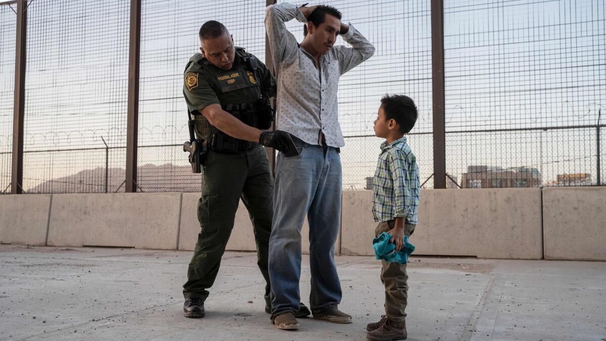 A Guatemalan man is searched by a Customs and Border Protection agent after he and his 7-year-old son crossed the border in El Paso on May 16.