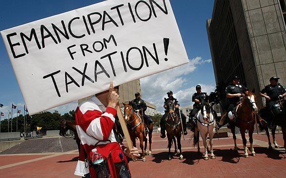 Santa Ana police on horseback watch as protesters leave an anti-tax rally at the Santa Ana Civic Center.