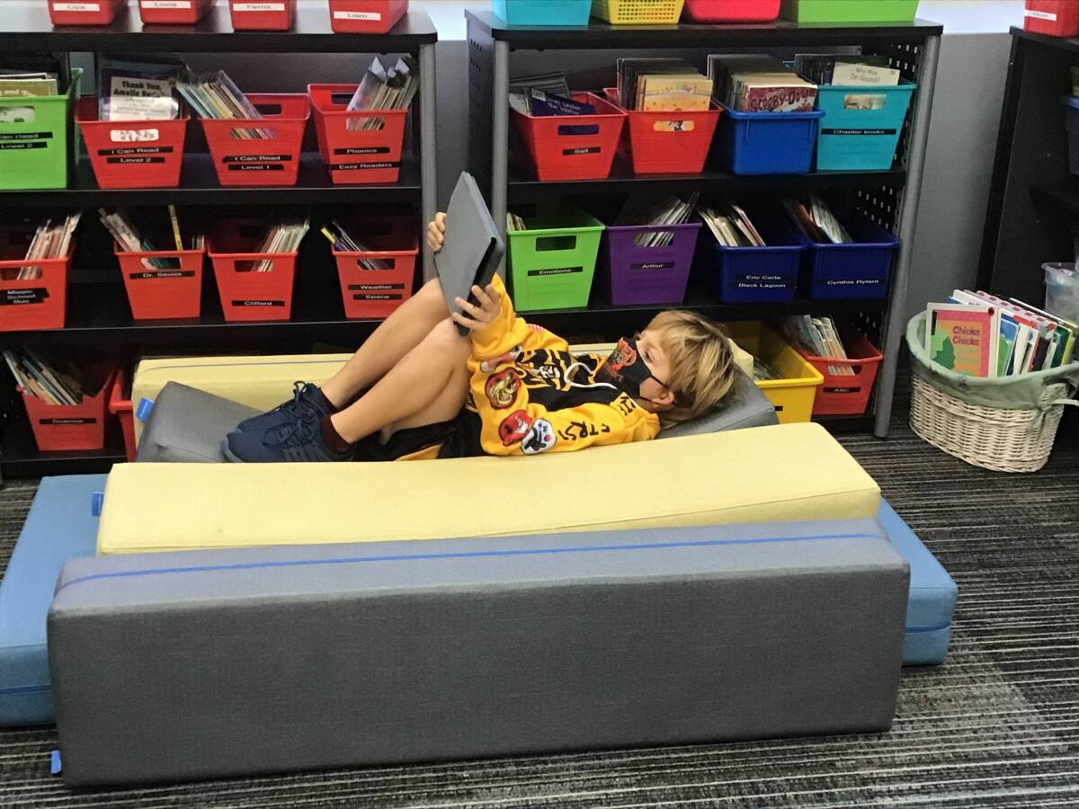 A student gets comfortable on a stadium seat in the classroom.