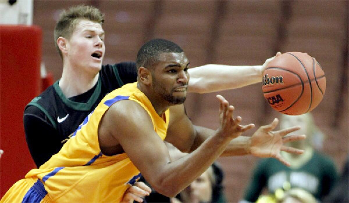 UC Santa Barbara center Alan Williams, right, takes a pass as Cal Poly forward Brian Bennett defends in the first half of the Mustangs' upset victory over the Gauchos, 69-38.