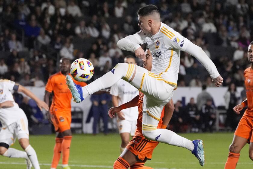 LA Galaxy forward Gabriel Pec, top, kicks the ball while under pressure from Houston Dynamo.