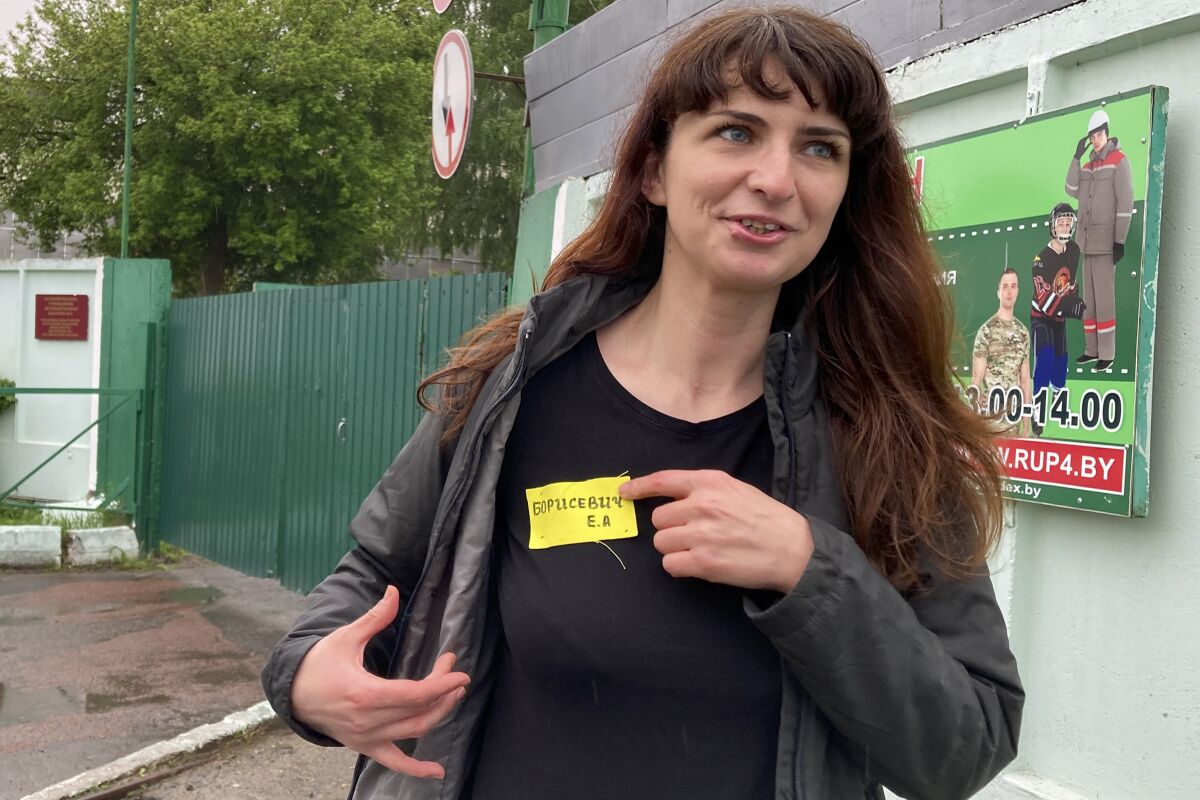 Belarusian journalist points to yellow tag on shirt