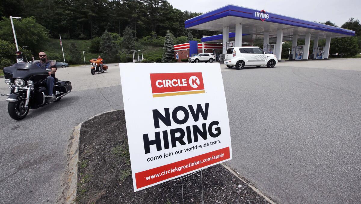 A "now hiring" sign is posted outside a gas station in Raymond, N.H.