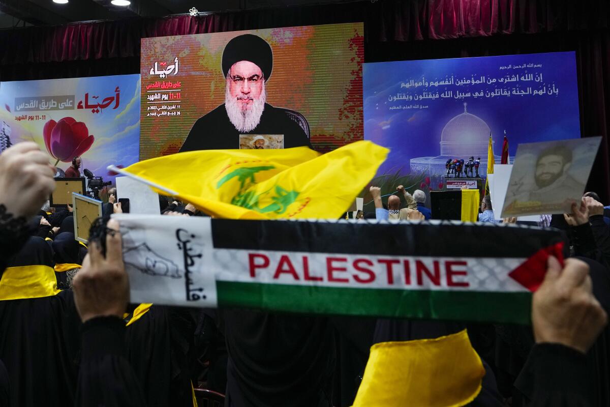 Partidarios de la milicia Hezbollah saludan con el puño en alto al escuchar un discurso del dirigente Hassan