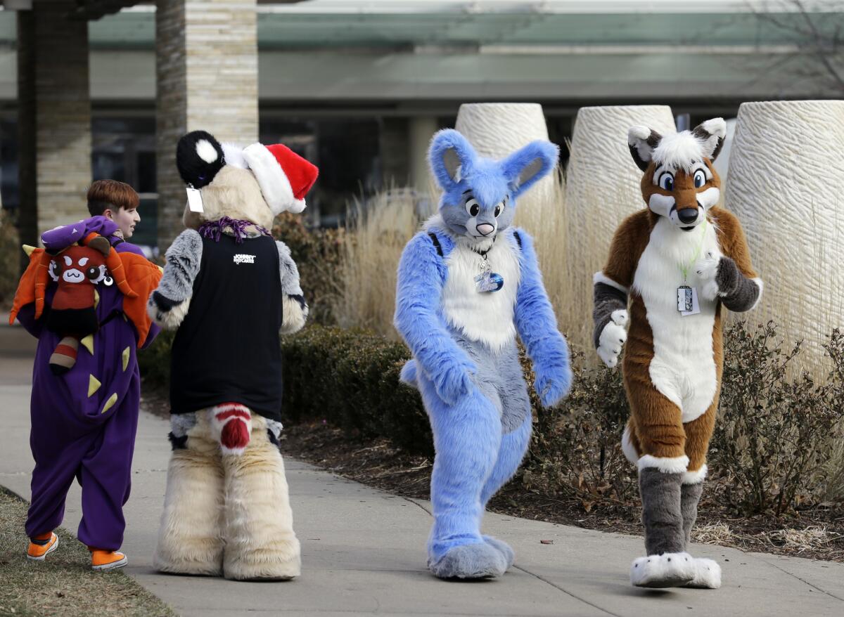 Frederic Cesbron, right, and Maxim Durand walk on the street outside the Hyatt Regency O'Hare hotel on Dec. 7 in Rosemont, Ill. Thousands of people were evacuated after a chlorine gas leak at the hotel hosting the 2014 Midwest FurFest convention.