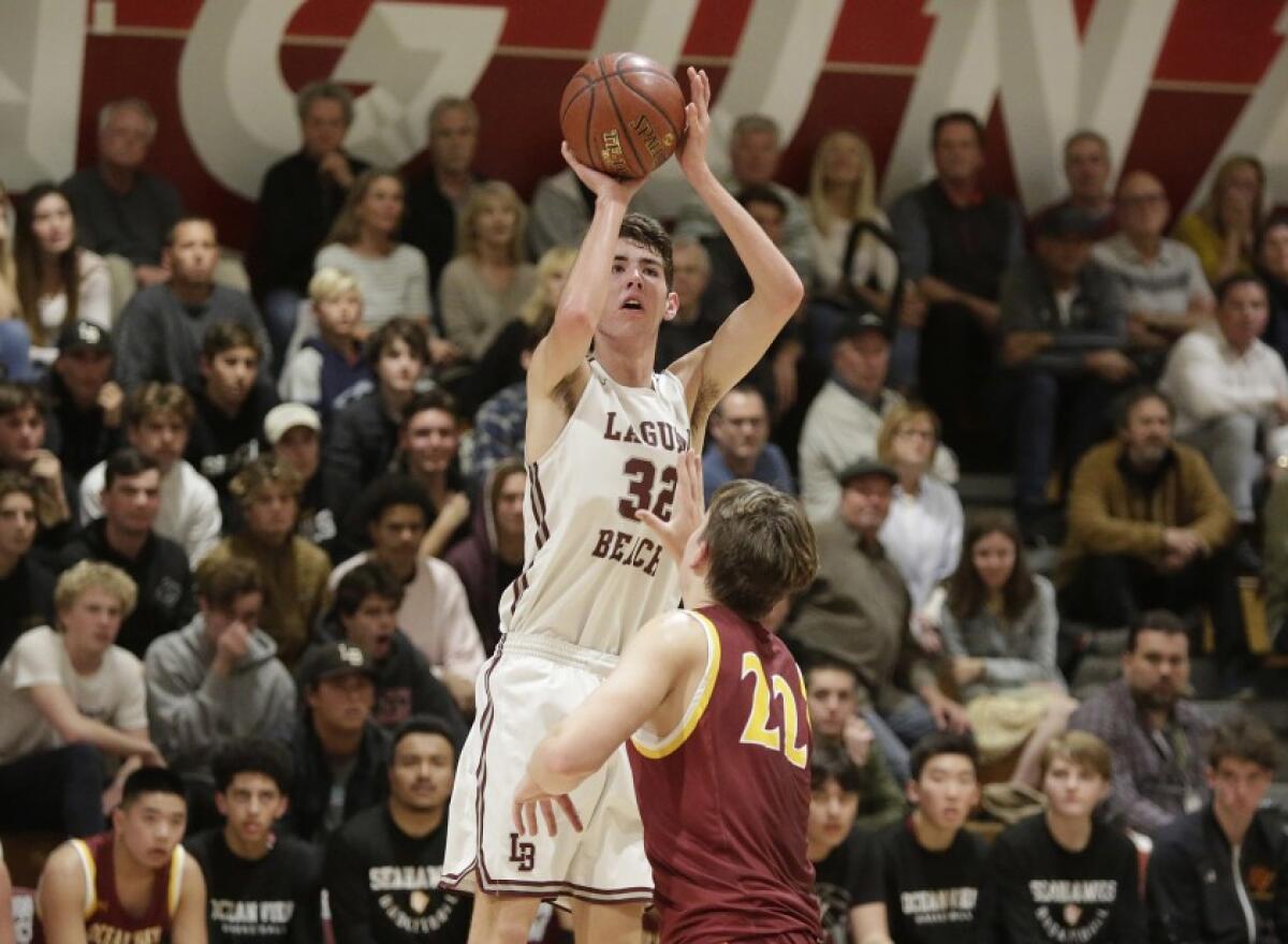 Laguna Beach’s Nolan Naess shoots a jumper as Ocean View’s Slater Miller defends in the first round of the CIF Southern Section Division 3AA playoffs on Feb. 12.