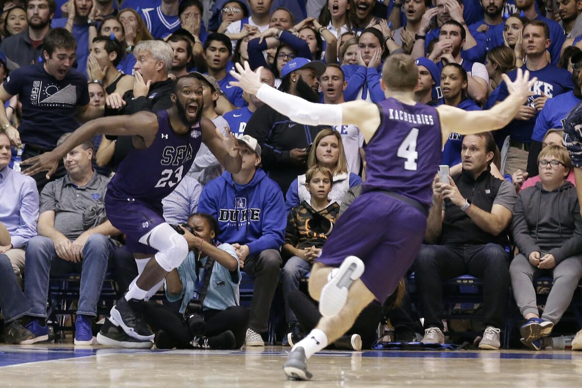 A jubilant Nathan Bain runs toward teammate David Kachelries after scoring the winning basket.