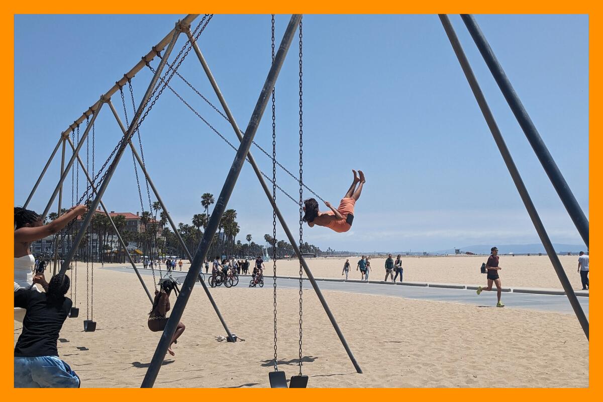 People swing next to a sandy beach. 