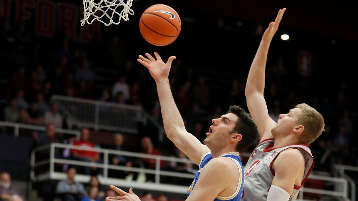 UCLA forward Gyorgy Goloman, left, puts up a shot against Stanford forward Michael Humphrey during the first half on Thursday.