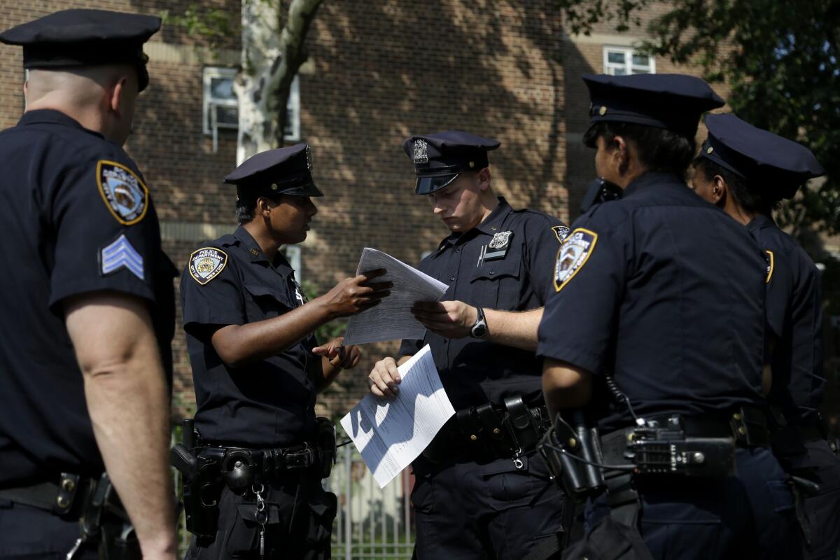 New York police officers take a report from a woman whose phone was stolen in the Brownsville section of Brooklyn.