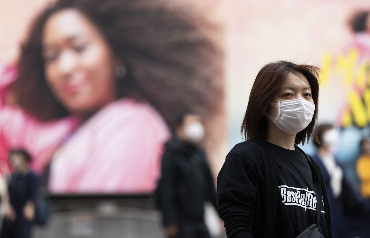 A woman wearing a face mask on a Tokyo street. 