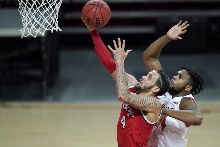 Ohio State guard Duane Washington Jr., left, goes up for a shot against Maryland forward Donta Scott during the second half of an NCAA college basketball game, Monday, Feb. 8, 2021, in College Park, Md. Ohio State won 73-65. (AP Photo/Julio Cortez)