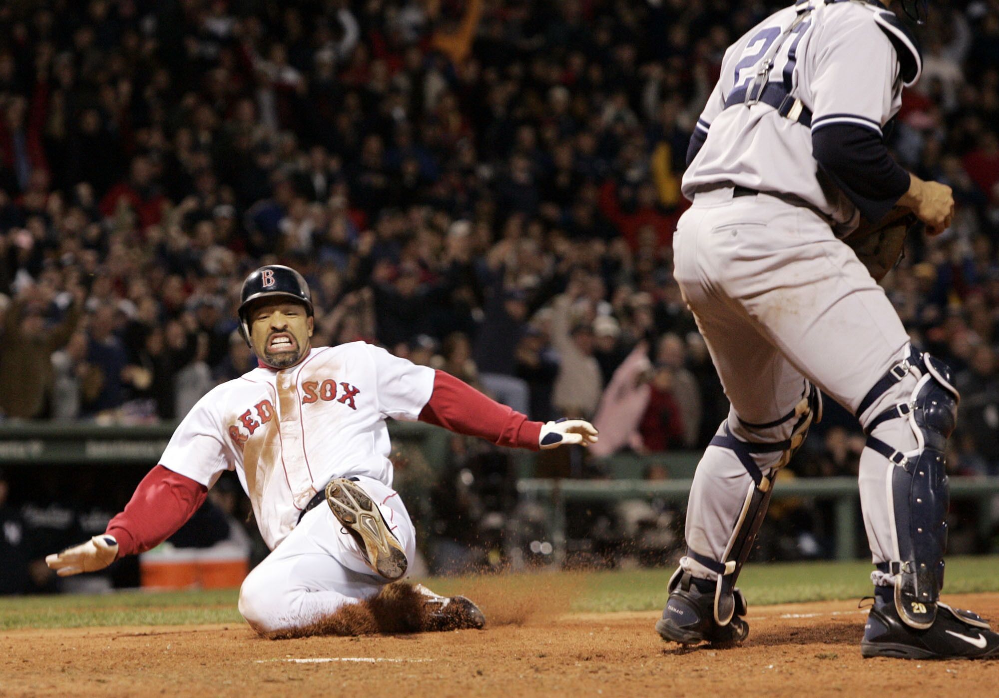 Boston Red Sox's Dave Roberts, left, slides home to score the tying run against the New York Yankees.