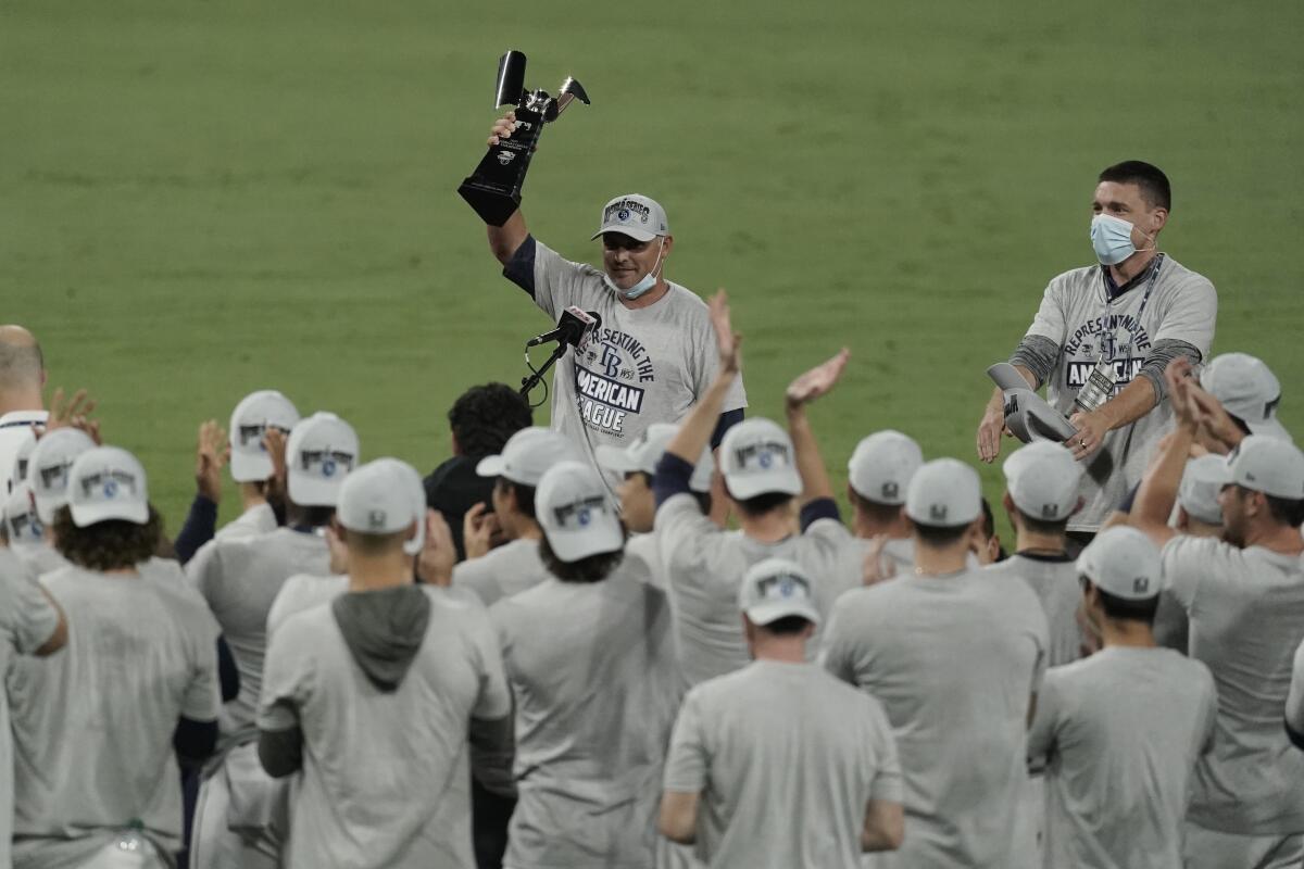 Tampa Bay Rays manager Kevin Cash holds the American League championship trophy after beating the Houston Astros on Saturday.