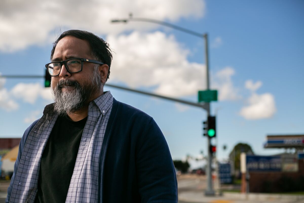 Jason Magabo Perez walks on the corner of Genesee Avenue and Clairmont Mesa Boulevard in San Diego.